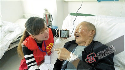 志愿者邓丽娜给庹长发播放京剧《关云长忠义千秋》选段。